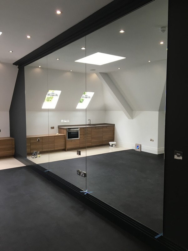 Frameless glass partition in loft conversion by Wimbledon glaziers