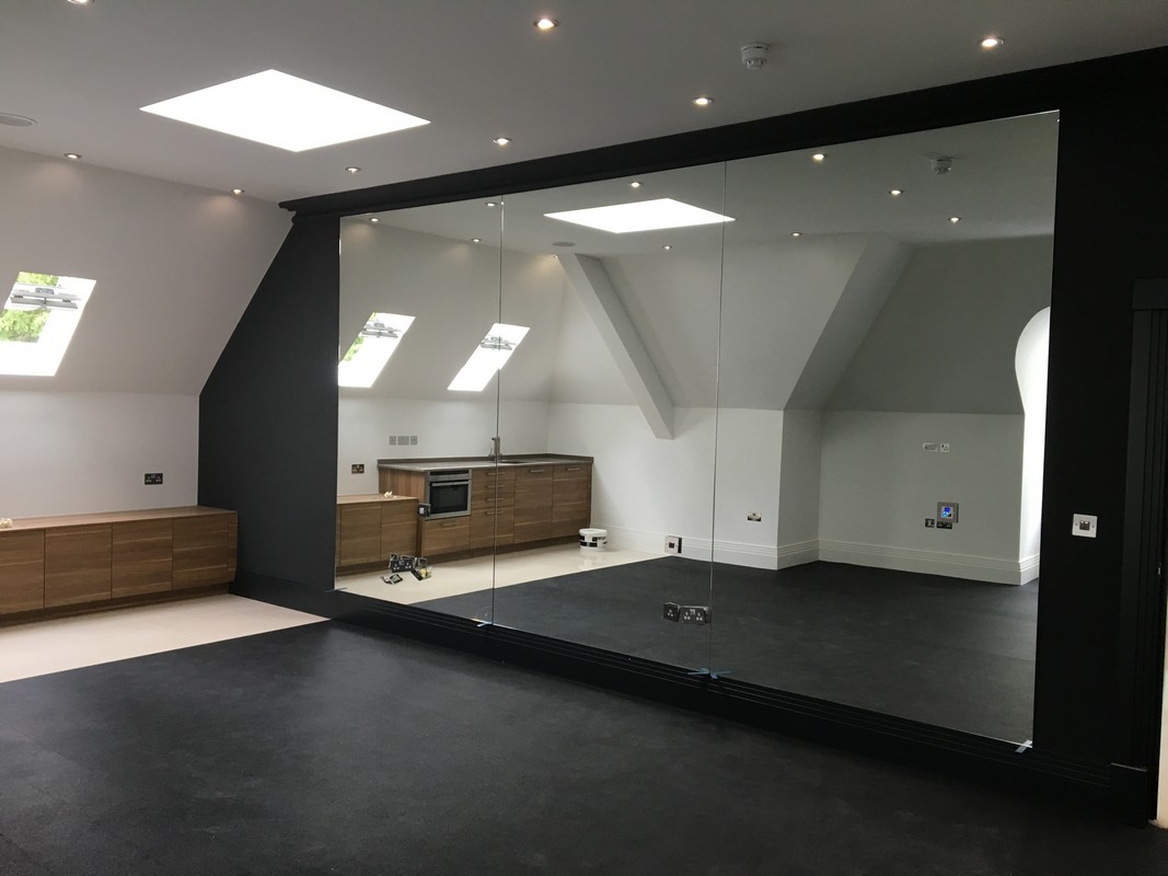 Frameless glass wall dividing loft conversion in Wimbledon